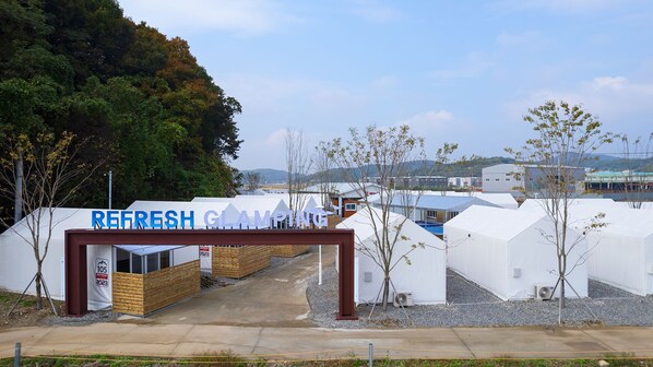 A campground entrance with a sign reading "REFRESH GLAMPING" and a wooden structure labeled "105 REFRESH 2023". - Hwaseong Refresh Glamping & Caravan (Hwaseong)