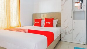 Ένα δωμάτιο ξενοδοχείου με ένα κρεβάτι, μια ντουλάπα και έναν καθρέφτη.