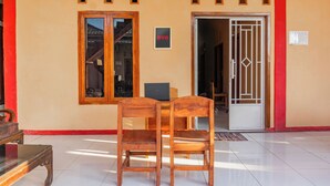 Ένα δωμάτιο με ένα ξύλινο γραφείο, δύο καρέκλες, έναν φορητό υπολογιστή και μια πόρτα με μεταλλική θύρα.