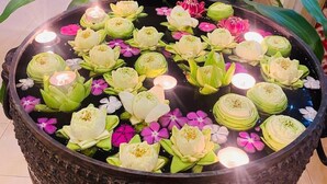 Een groot decoratief vijver met lotusbloemen en kaarsen in een ontvangstruimte.