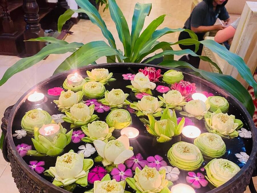 A large decorative pond with lotus flowers and candles in a lobby area.
