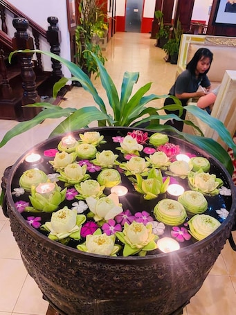 A large decorative pond with lotus flowers and candles in a lobby area.