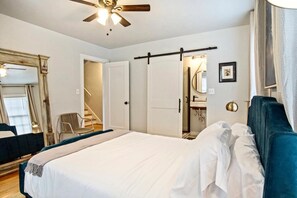 Relax in comfort with a large bed, ceiling fan, and convenient seating area.