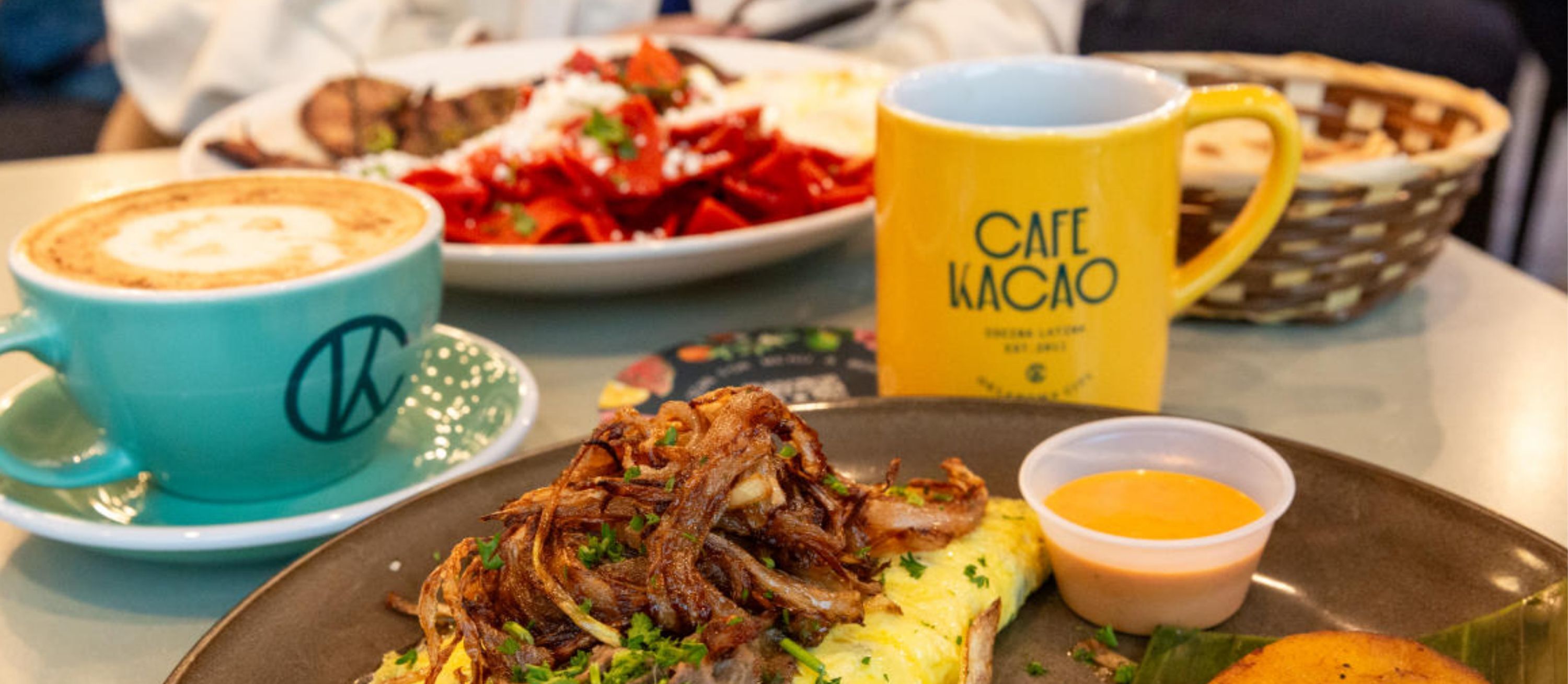 A meal with shredded meat, mashed potatoes, and a side of sauce, accompanied by a coffee cup and a yellow mug with text.