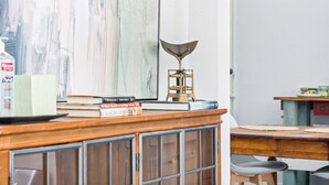 A room with a wooden desk, books, a lamp, and a large abstract painting on the wall. - Adorned Studio 3min-asian Dist Rain Shower (Oklahoma City)