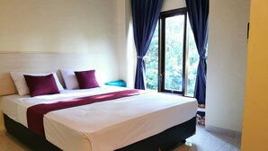 A neatly made bed with white and purple bedding, a dark headboard, and a window with blue curtains. - Hotel O Majest (Bontang)