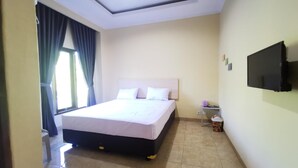 A hotel room with a bed, a television, a small table, and a trash bin. - Hotel O Majest (Bontang)