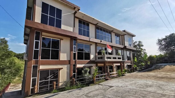 A multi-story building with large windows and a flag. - Hotel O Majest (Bontang)