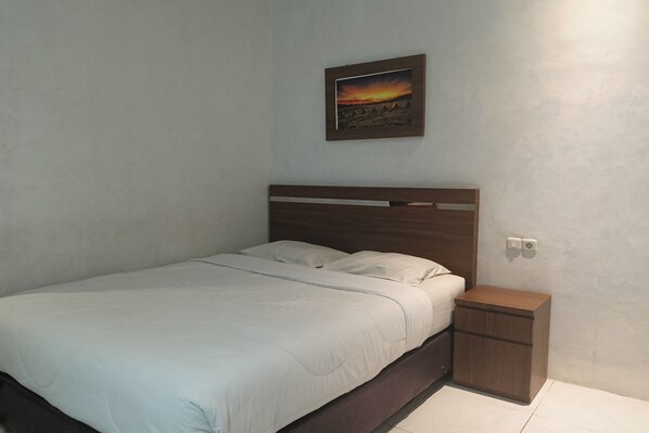 Un dormitorio con una cama individual, una mesita de noche y un cuadro enmarcado en la pared.