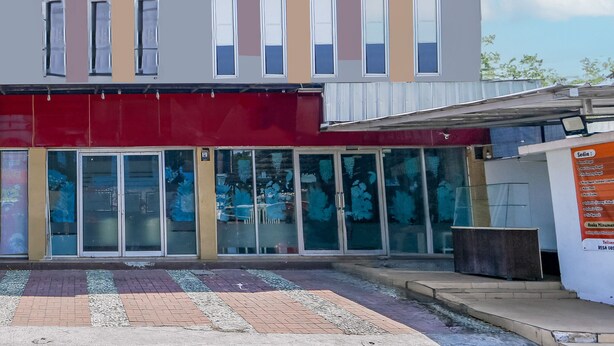A modern building with a flat roof, large windows, and a red awning. - Hotel O Sman House (Bekasi)