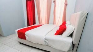 A bed with white bedding and red accents, a red throw blanket, and a red pillow. - Hotel O Sman House (Bekasi)