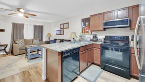 Una cocina compacta equipada con lavavajillas, horno, microondas y refrigerador.