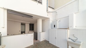 Una cocina limpia y moderna con armarios blancos, un lavamanos integrado y un salpicadero de azulejos.