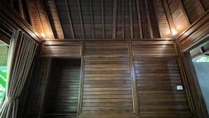 Ein Zimmer mit Holzwandverkleidung und schrägem Dach.