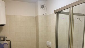 A compact bathroom with a toilet, bidet, and a glass-enclosed shower. - Green Oasis 1 (Lerici)