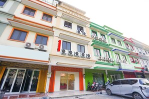 Un edificio a più piani con diversi negozi, tra cui un negozio Ace.