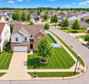 A suburban residential area with houses, green lawns, and a clear sky. - Charming 4-bedroom house with AC and WiFi in lovely Indianapolis (Indianapolis)