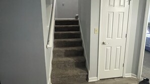 A staircase leading to a second floor, a white door, and a wooden floor. - Charming 4-bedroom house with AC and WiFi in lovely Indianapolis (Indianapolis)