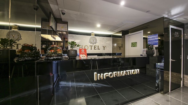 Ein Hotel-Empfangsbereich mit Marmor-Theke, einem Empfangsschalter und einem Schild für den Informationsschalter.