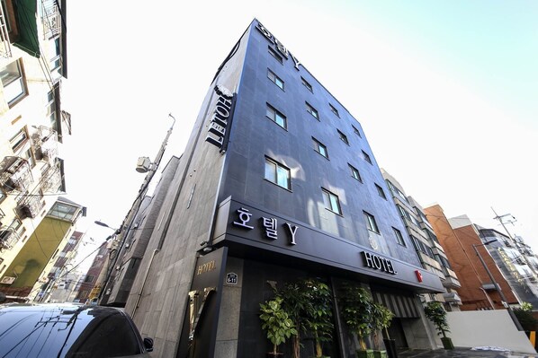 A modern hotel with a dark facade, multiple windows, and a sign indicating it is a hotel. - Eunpyeong Y HOTEL (Seoul)