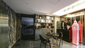 Eine moderne Küche mit Essbereich, inklusive Marmorrückwand, Mikrowelle und Kaffeemaschine.