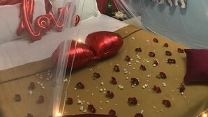 A room with a bed covered in rose petals, red heart-shaped balloons, and a canopy. - Le Apex Misty Stay (Ootacamund)