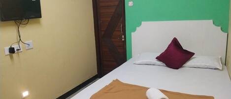 Una habitación de hotel con una cama, un televisor montado en la pared y una puerta de diseño original.
