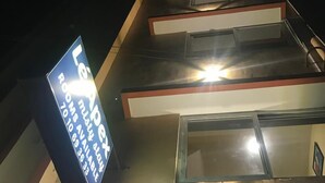 Een hotel met een bord waarop kamerbeschikbaarheid en contactnummers staan.