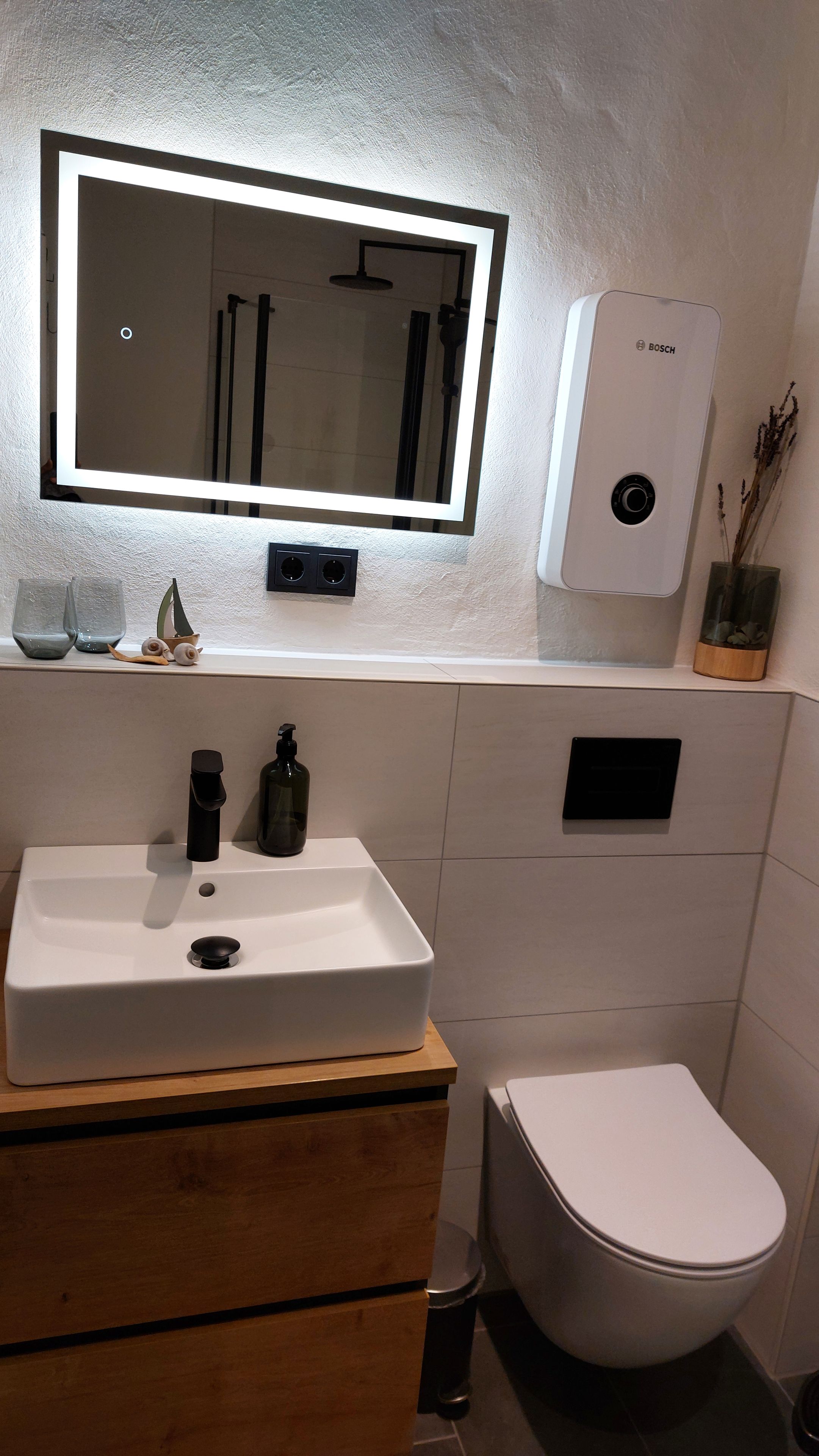 Ein Badezimmer mit einem weißen Waschbecken, Spiegel und WC.