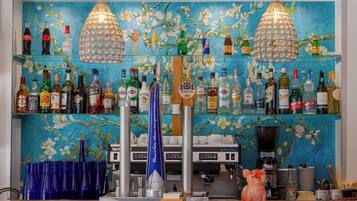 A bar area with a variety of liquor bottles, a coffee machine, and a decorative pig statue.