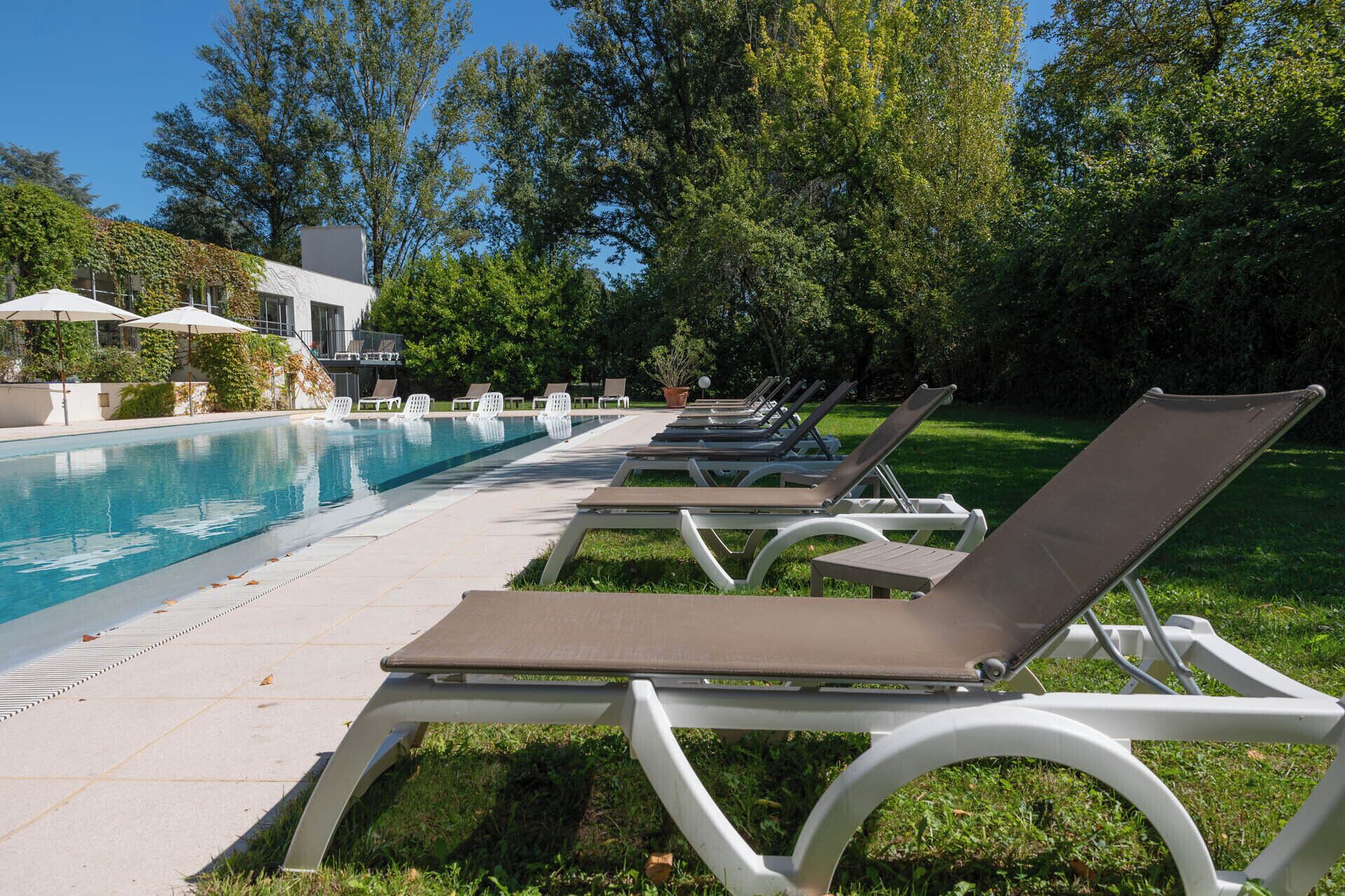 A poolside area with lounge chairs and umbrellas.