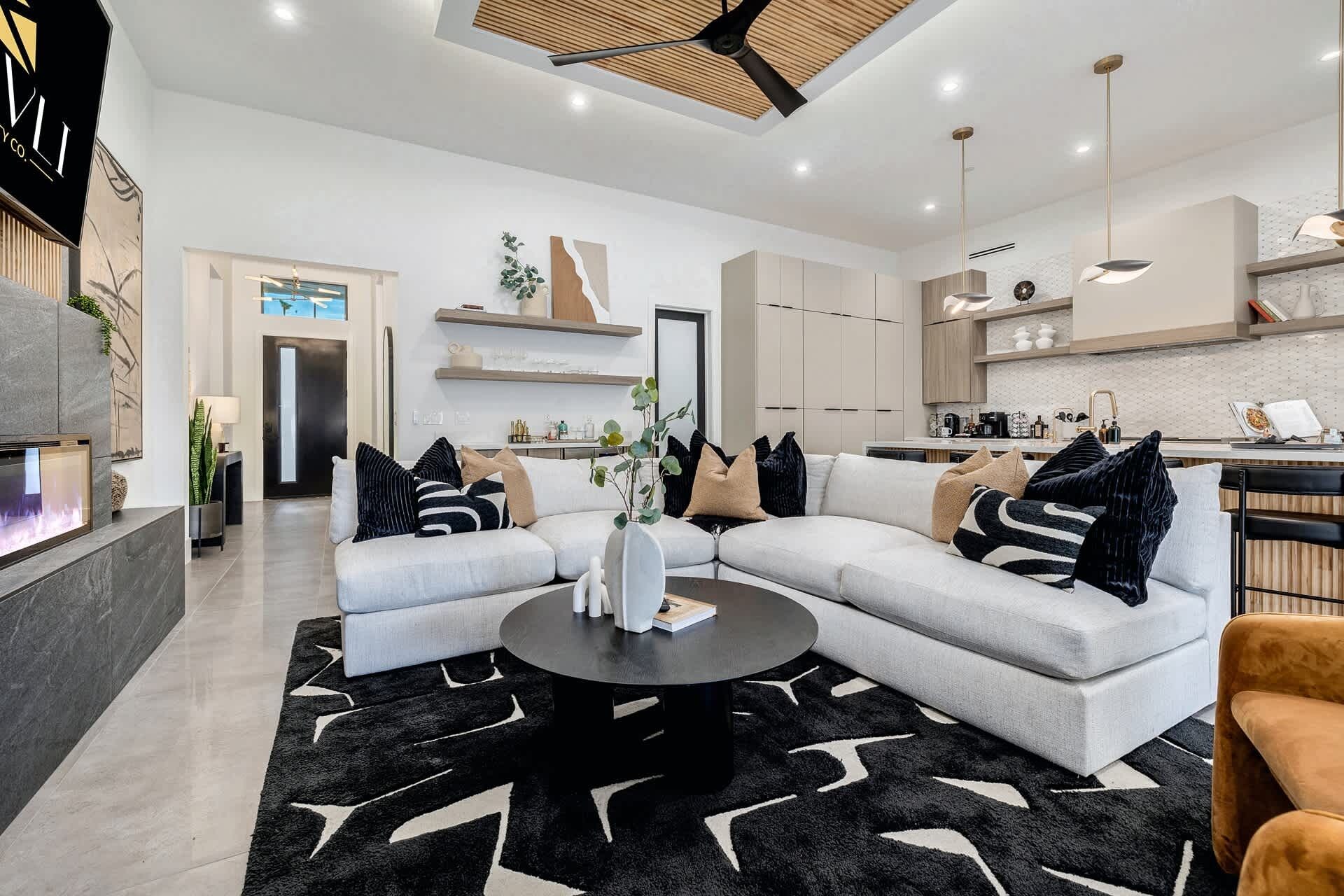 Una sala de estar moderna con un sofá modular, una mesa de centro y una chimenea.
