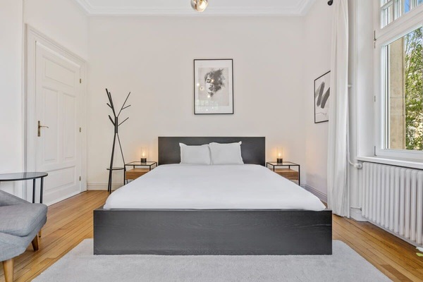 Relax in a cozy, light-filled bedroom with a plush double bed and serene decor, perfect for a restful night's sleep.