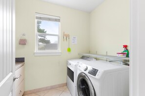 Une buanderie équipée d’un lave-linge, d’un étendoir et d’une fenêtre.