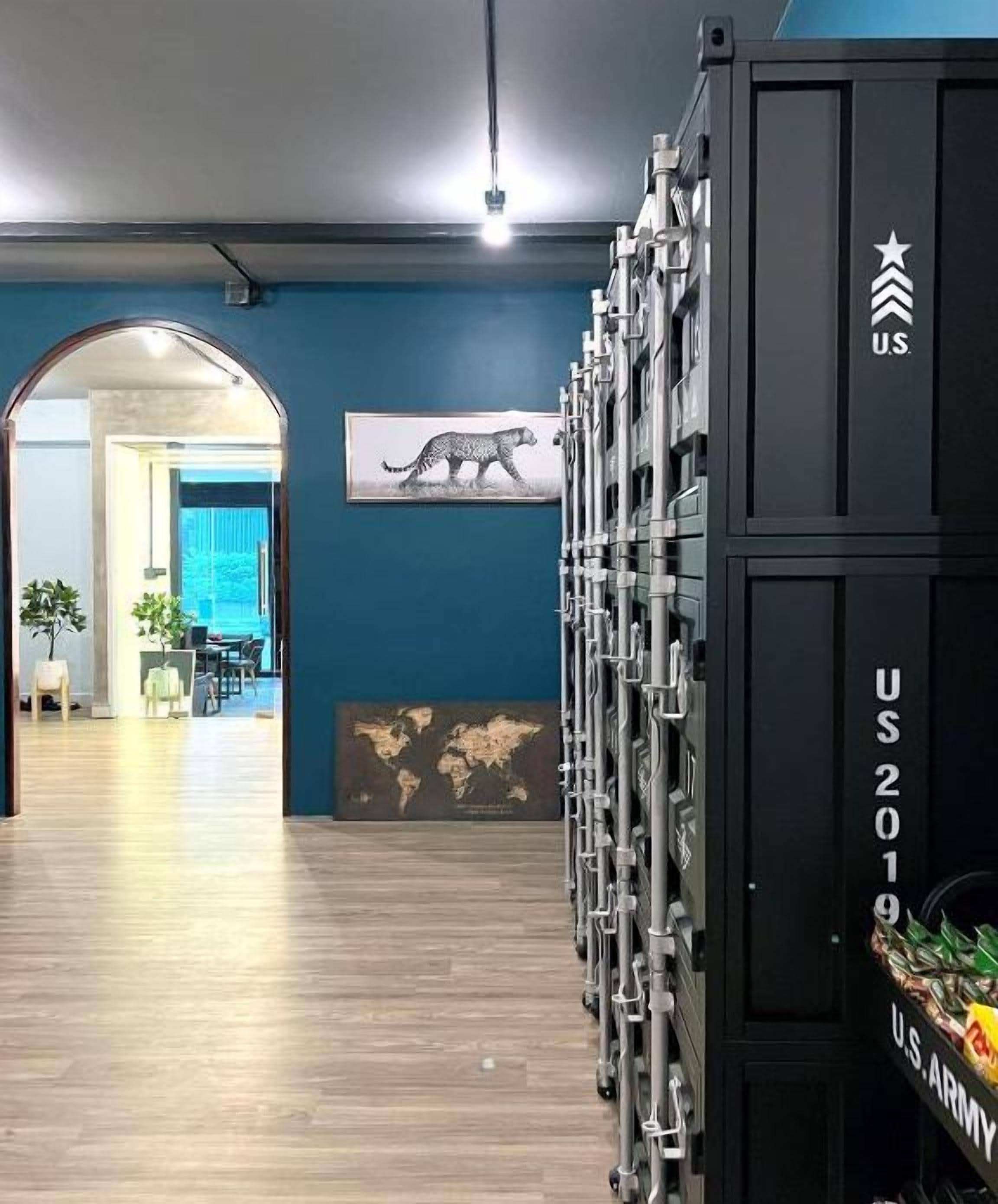 A modern interior with a wooden floor, a large black cabinet labeled "U.S. ARMY 2019", and a framed picture of a cheetah.