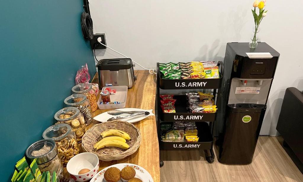 A buffet table with various food items and a coffee machine.
