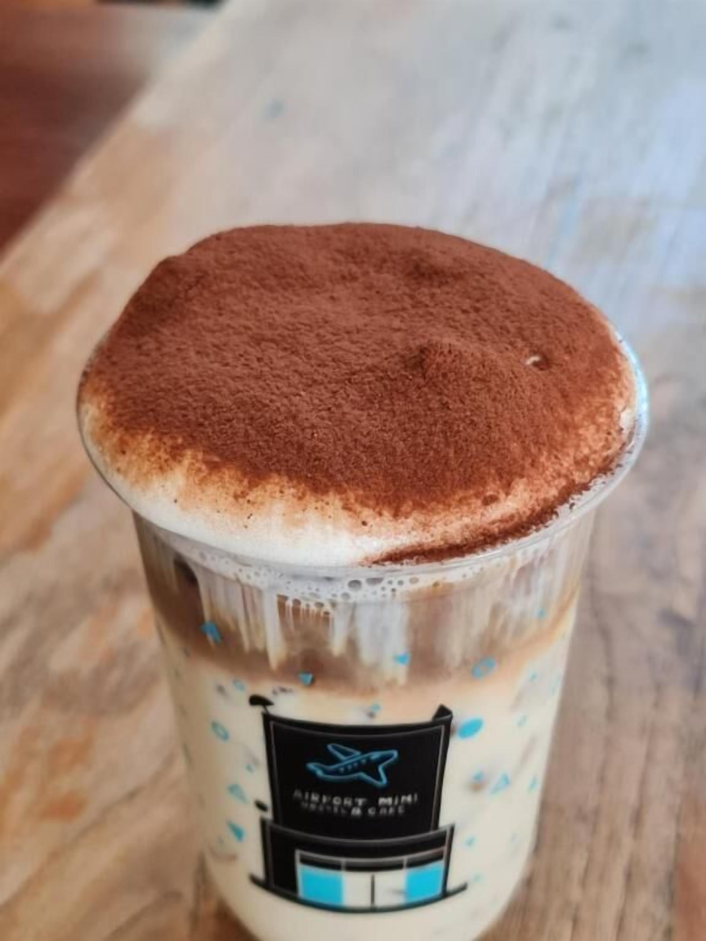 Una porzione di dessert con una schiuma in superficie e un'etichetta con un'illustrazione di un edificio.