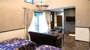 Une chambre d’hôtel avec un lit, un bureau, une chaise, une télévision et un lustre.