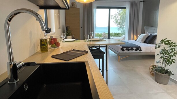 Una cocina moderna con lavamanos, comedor y una cama con vistas.