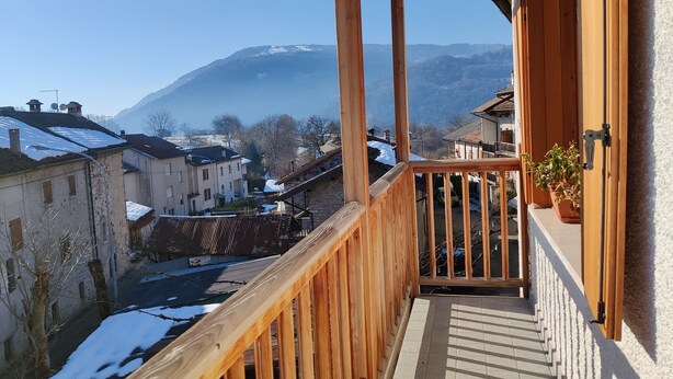 A wooden balcony with a view of a town and a mountain. - CasaZefira (Feltre)
