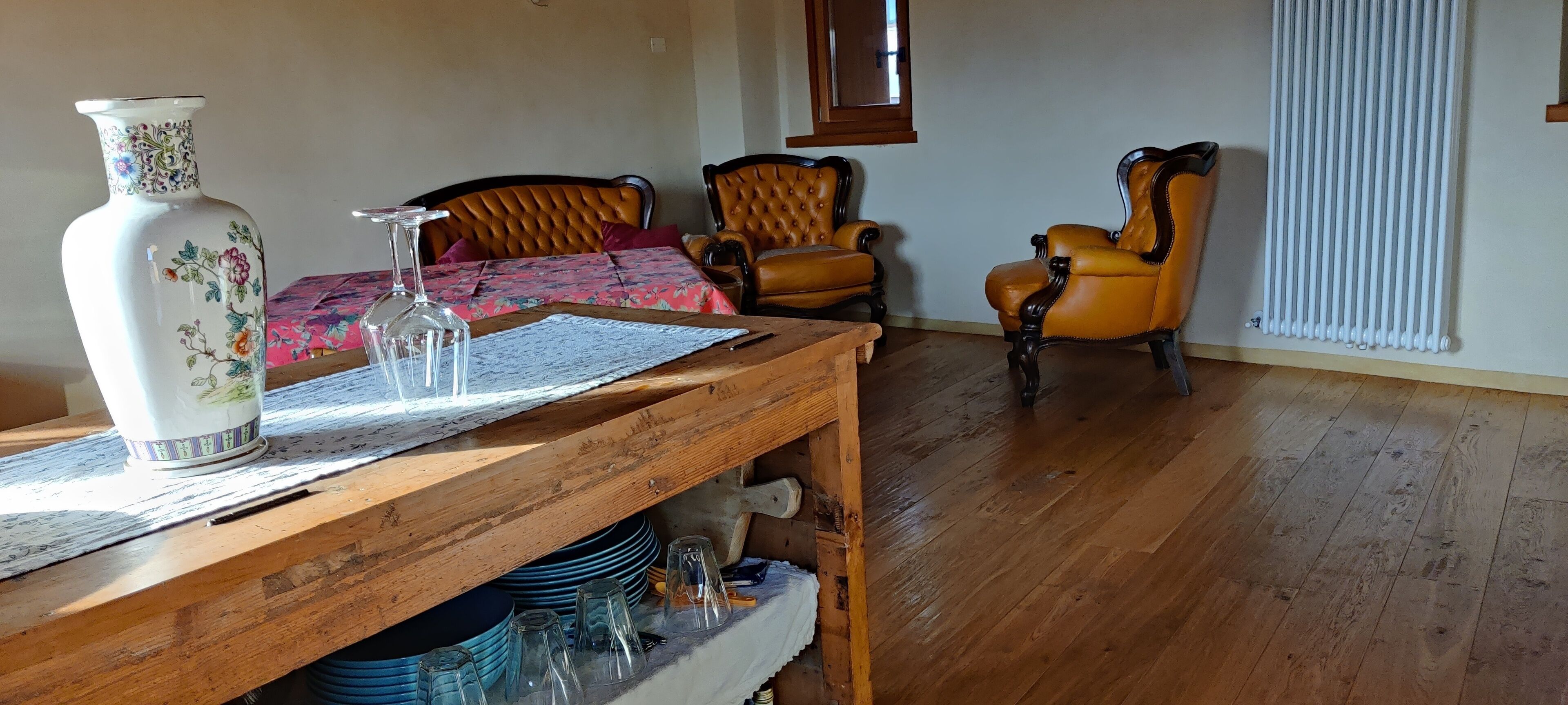 Una habitació amb una taula de fusta, un ram i dues cadires.