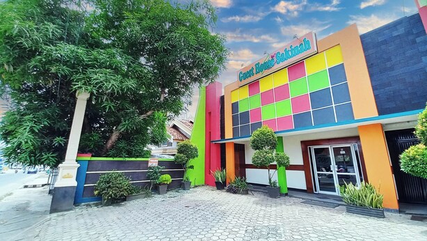 Un edificio colorido con un cartel que dice 'Guest House Sakinah'.