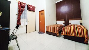Una habitación de hotel con dos camas, un escritorio y una silla.