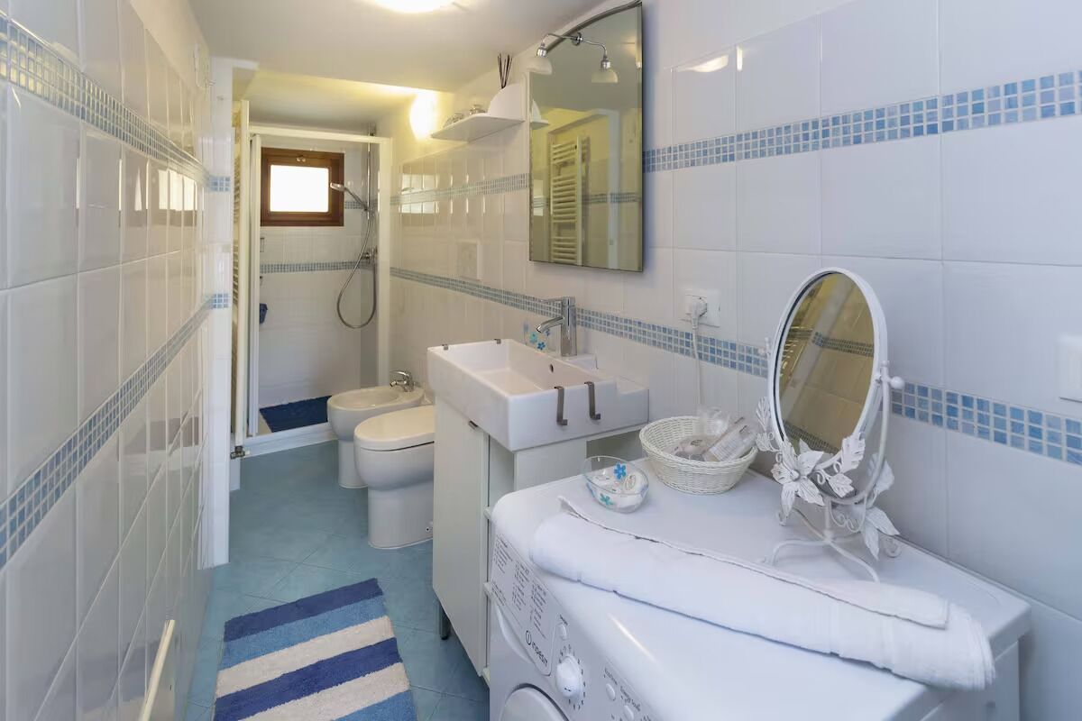 Ein Badezimmer mit Waschbecken, Spiegel und Waschmaschine.