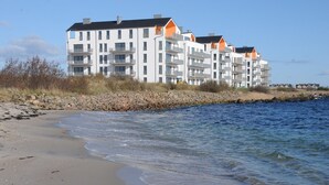 Um hotel à beira-mar com vários andares, varandas e vista para o mar.