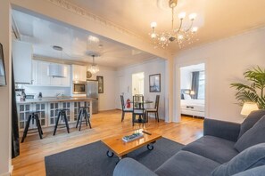 Una sala de estar moderna con un sofá, una mesa de centro y una zona de comedor con sillas y una mesa.