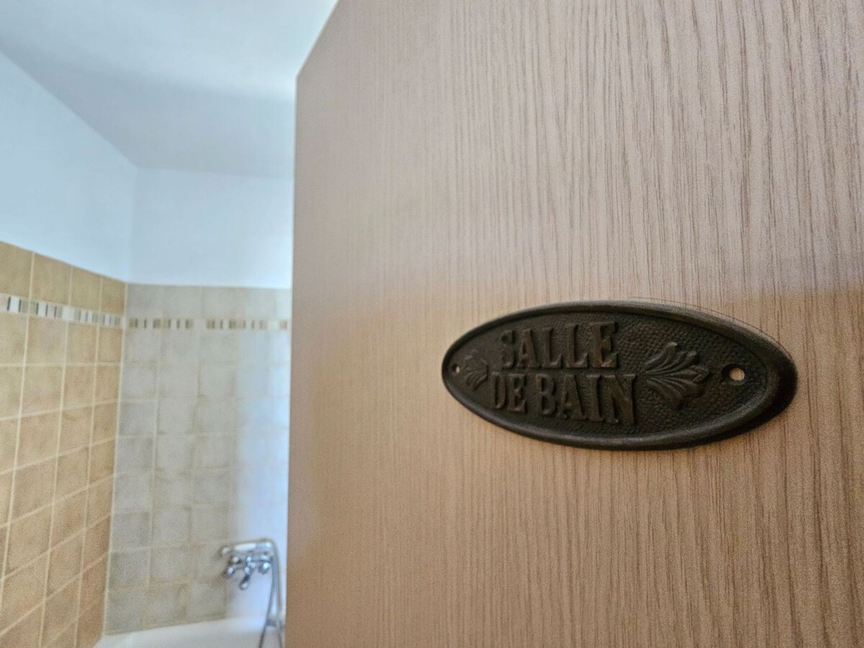 A bathroom with a shower and a sign that reads "Salle de Bain".