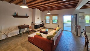 A cozy living room with a wooden ceiling, a sofa, a coffee table, and a fireplace.