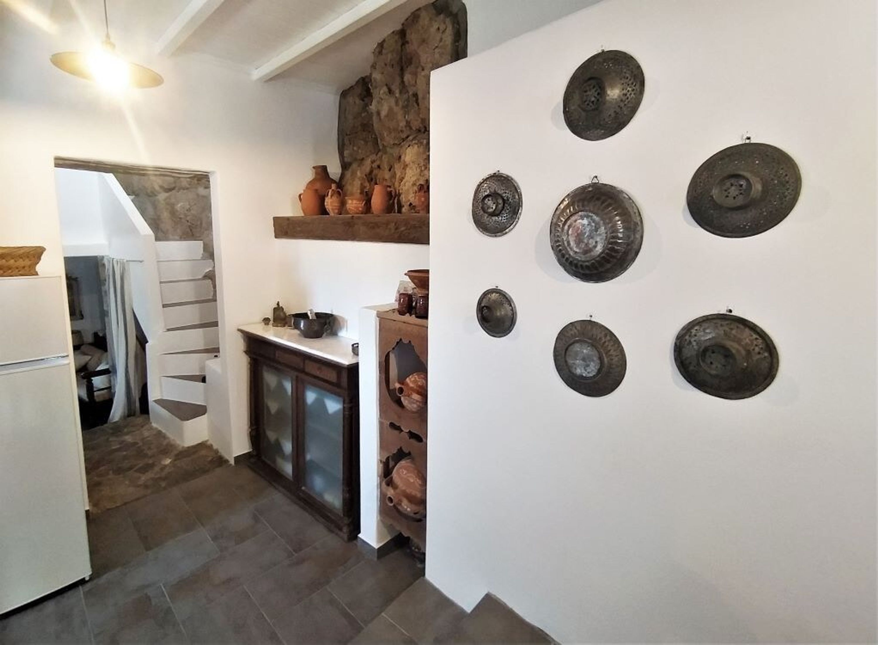 Eine Küche mit einer Steinwand, einer Treppe und einer Wandplatte-Sammlung.