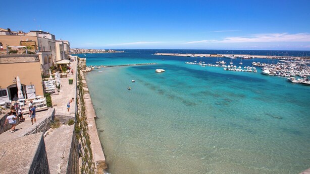 A coastal town with a marina, clear turquoise waters, and buildings along the waterfront. - 4065 Kalès Holiday by Barbarhouse (Otranto)